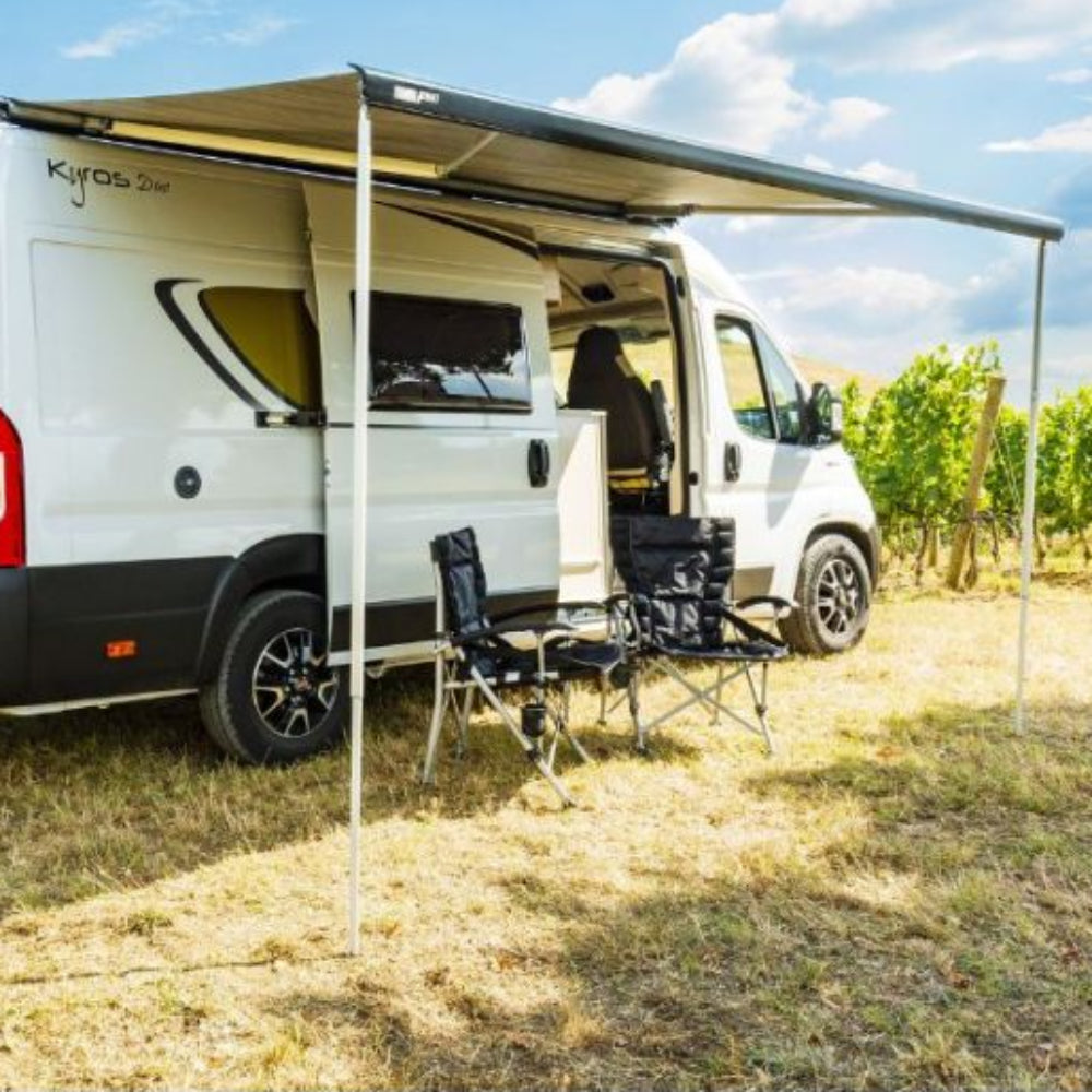 A white awning by a vehicle, with FIAMMA branding visible on the side, set up in an outdoor setting.