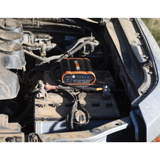 Car battery and jump starter in a vehicle's open hood along with proboost 25