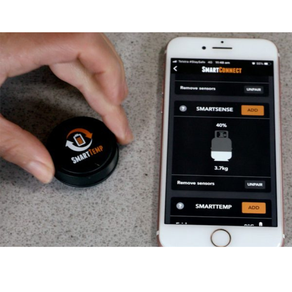 Hand holding a SmartTemp device next to a smartphone displaying the SmartConnect app.