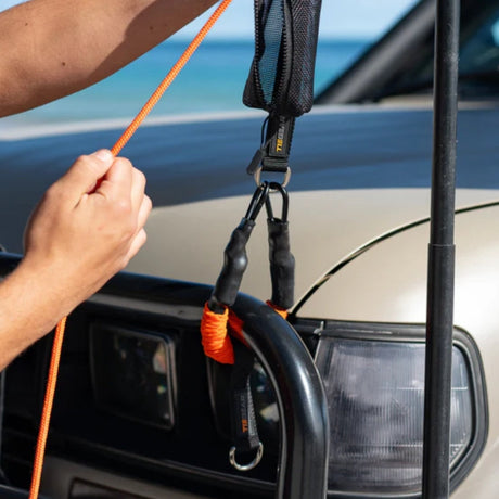 Person adjusting Tie Gear Soft Spring attached to the bumper bar of a vehicle