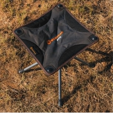 Compact camping stool with Wildcraft branding on a grassy background
